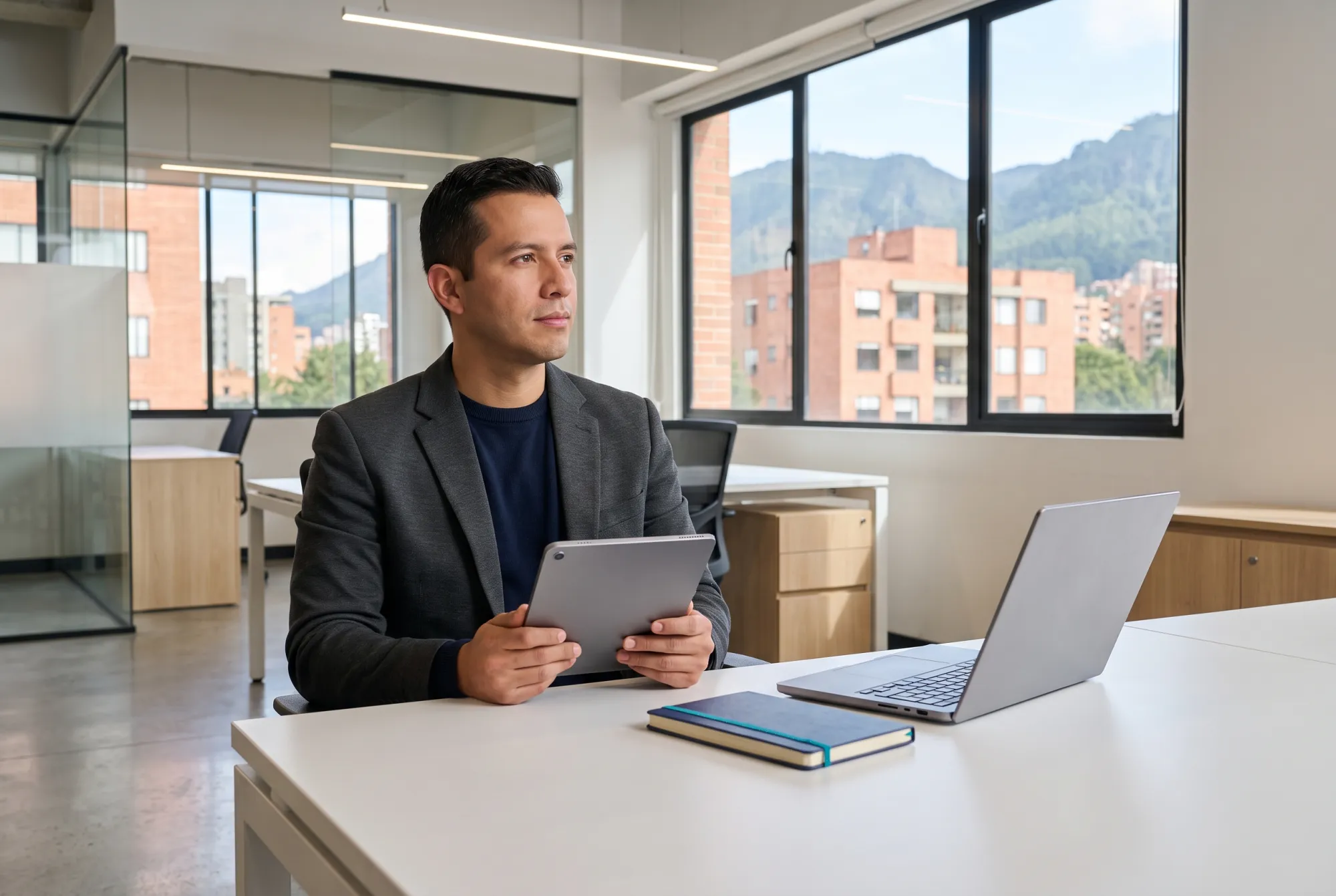 Contador en su oficina de Bogotá, con la tablet y el portátil listos para la validación