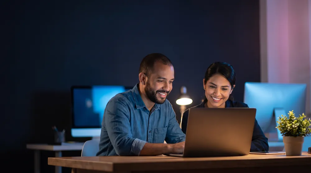 Dos personas del equipo de soporte revisando una web en una laptop